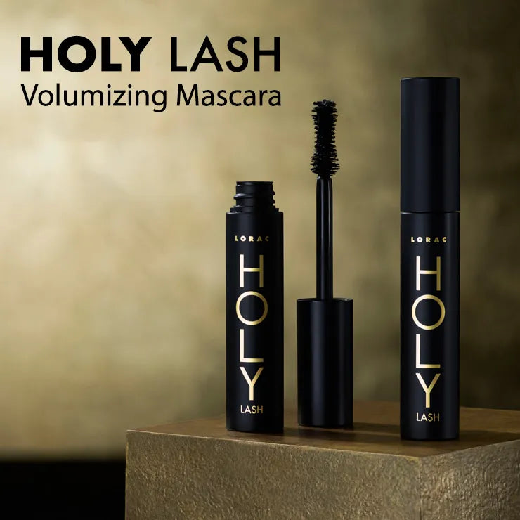 LORAC HOLY LASH Volumizing Mascara displayed with opened and closed tubes on a textured surface against a soft, blurred background